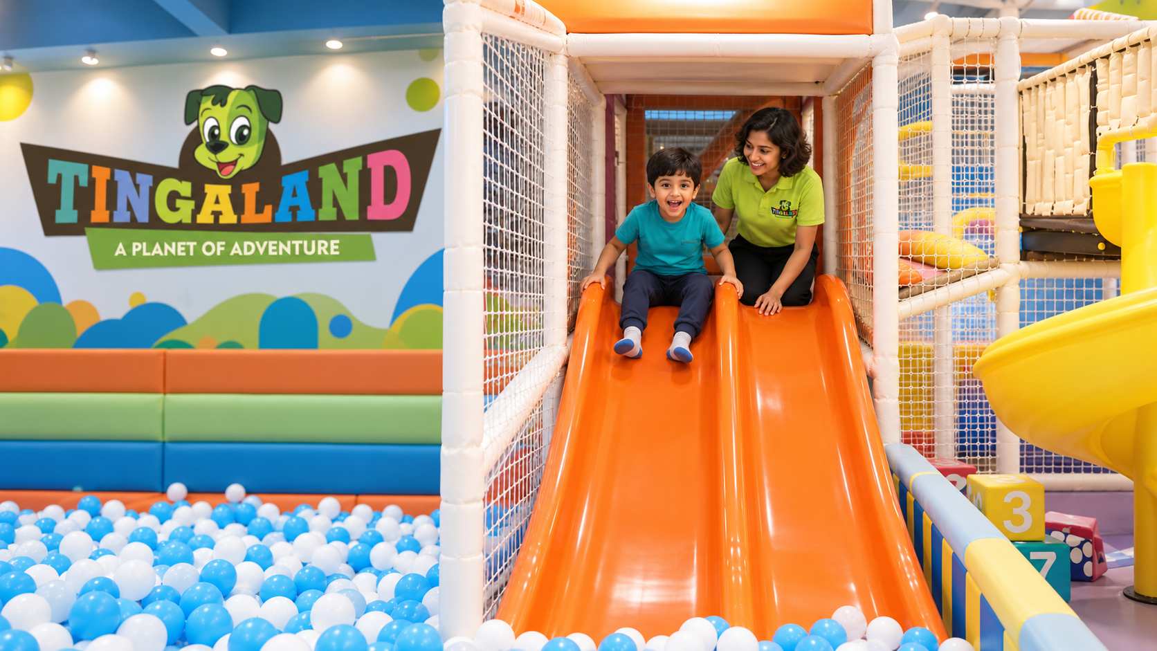Drop slide 2 Boy ready at the orange tingaland drop slides while a uniformed play attendant supervises