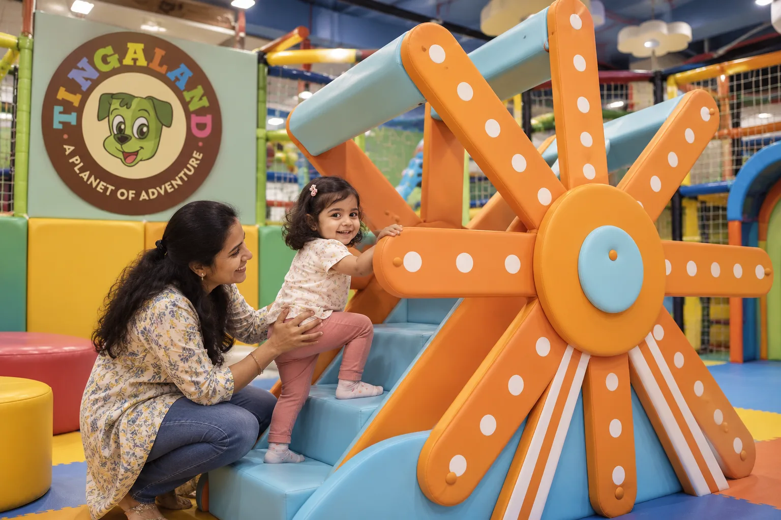 Parent helping a toddler enter the tingaland ferris wheel slide