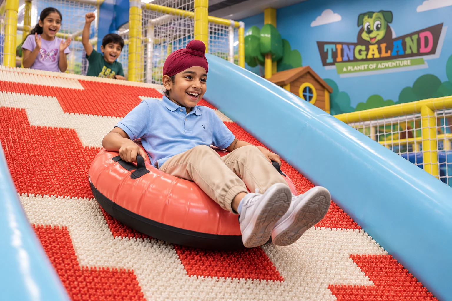 Sikh boy riding a coral donut ring down the textured slide