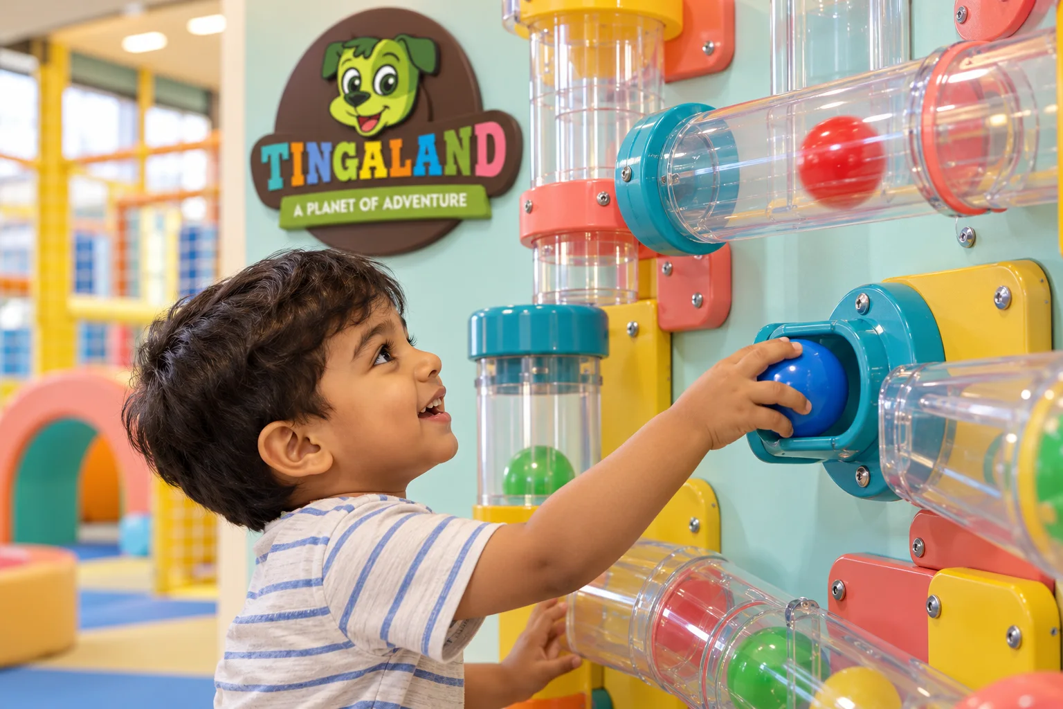 Child places a blue ball into a clear maze tube