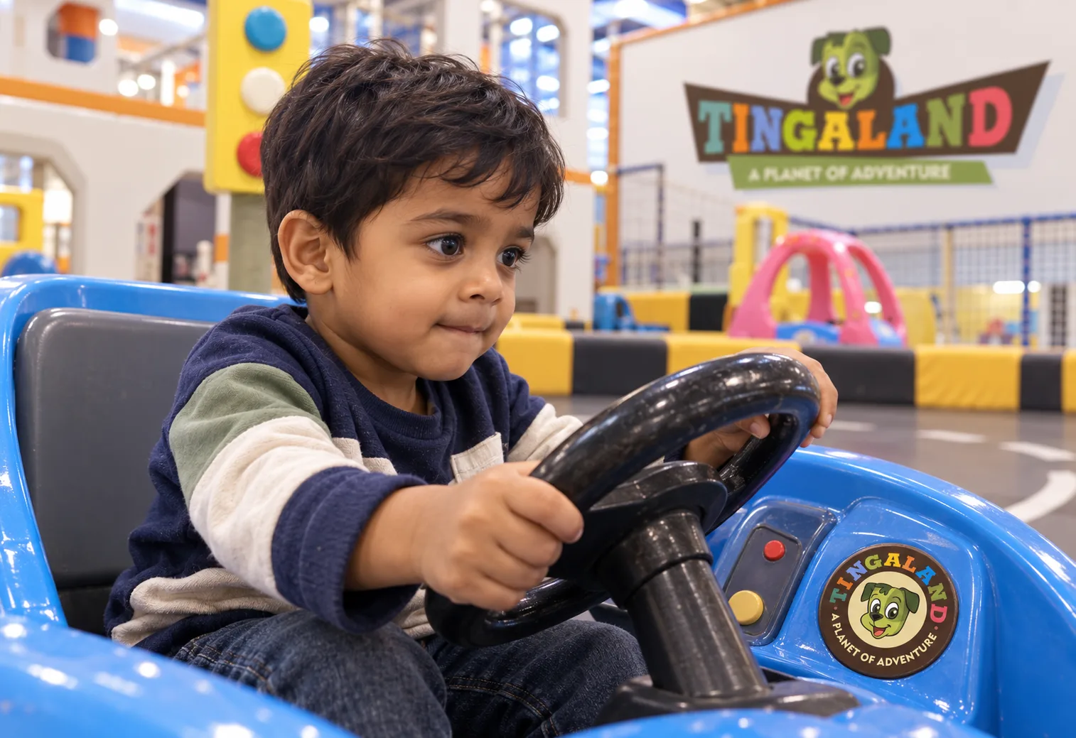 Toddler steering a branded tingaland kiddy car