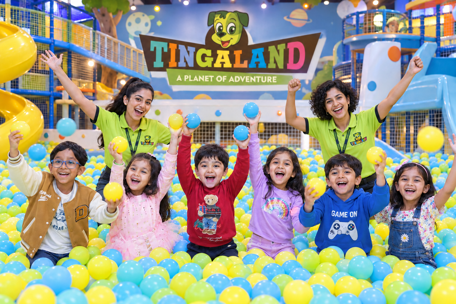 Ball pool 26 Children and female tingaland helpers celebrating together in the ball pool